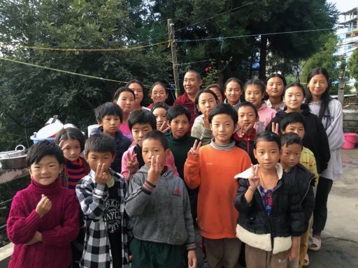 Grupo de niños y adultos sonriendo y posando juntos al aire libre.