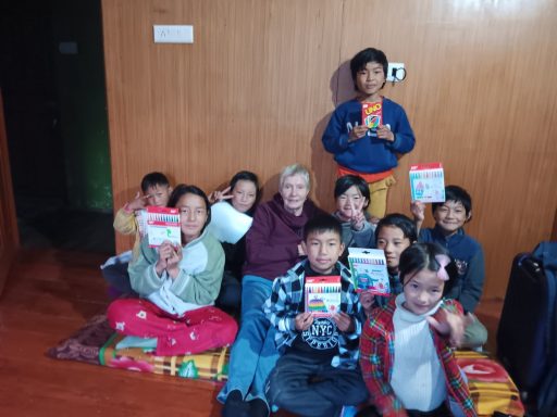 Grupo de niños sonriendo y sosteniendo libros en un ambiente interior acogedor.